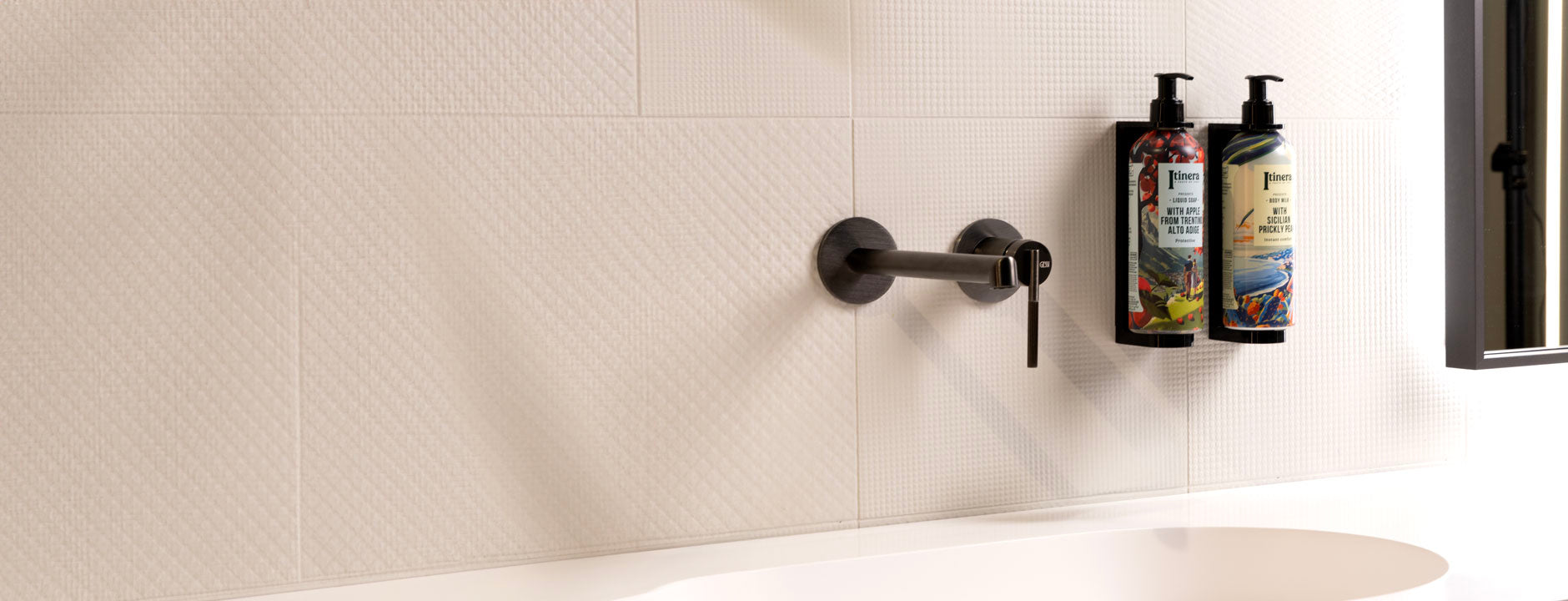 Wall-mounted Itinera dispensers beside a basin